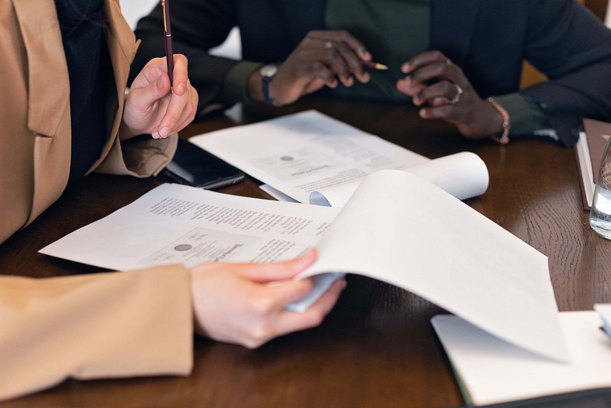 Hands reviewing and discussing a set of documents at a table