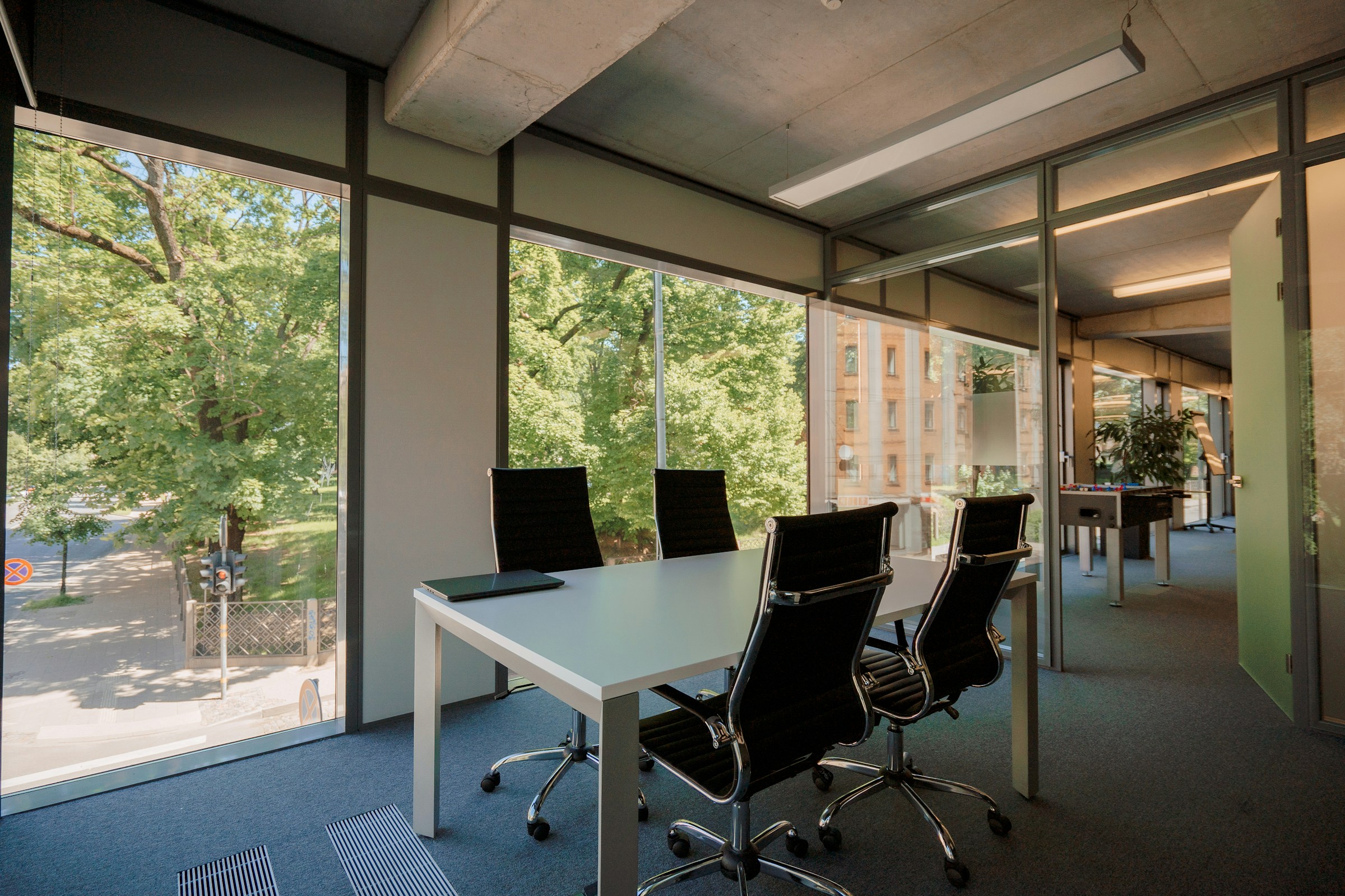 Daylight in a meeting room with glass partitions and a shared table